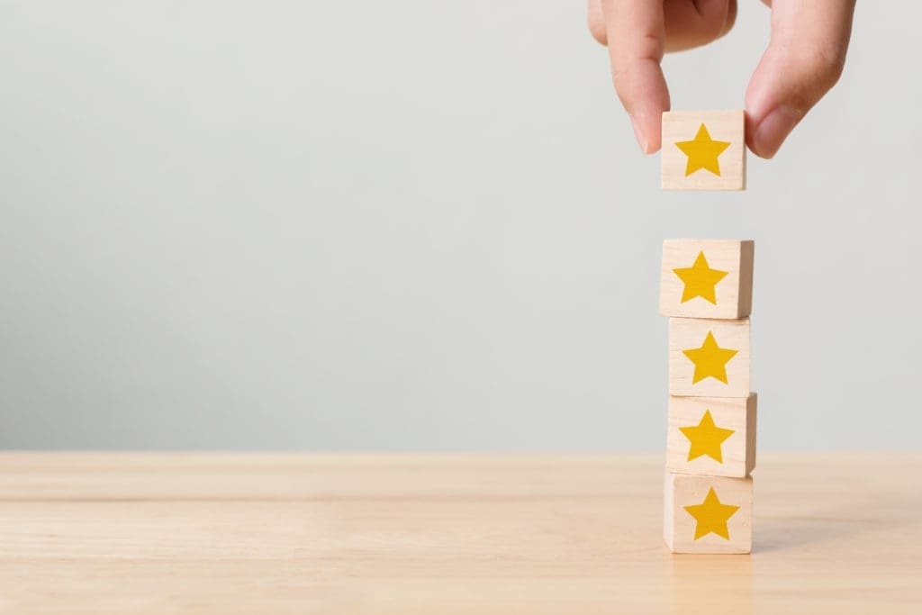 A person stacking wooden blocks with stars on them.