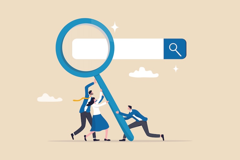 Illustration of three individuals working together to hold up a large magnifying glass in front of a search bar, symbolizing teamwork and search. The background is beige with a few clouds.