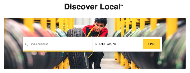 A person in a red and black jacket is placing a tire on a shelf in a tire store. The image is overlaid with search fields labeled "Find a business," "Little Falls, NJ," and a yellow "Find" button under a header reading "Discover Local.