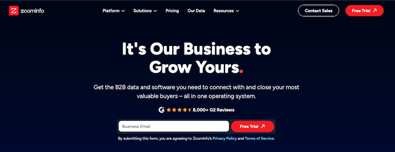 Screenshot of a website homepage for ZoomInfo. The page has a dark background with white text stating, “It’s Our Business to Grow Yours.” Below is a call to action to connect with valuable buyers. There's a field to input a business email and buttons for "Free Trial" and "Contact Sales.